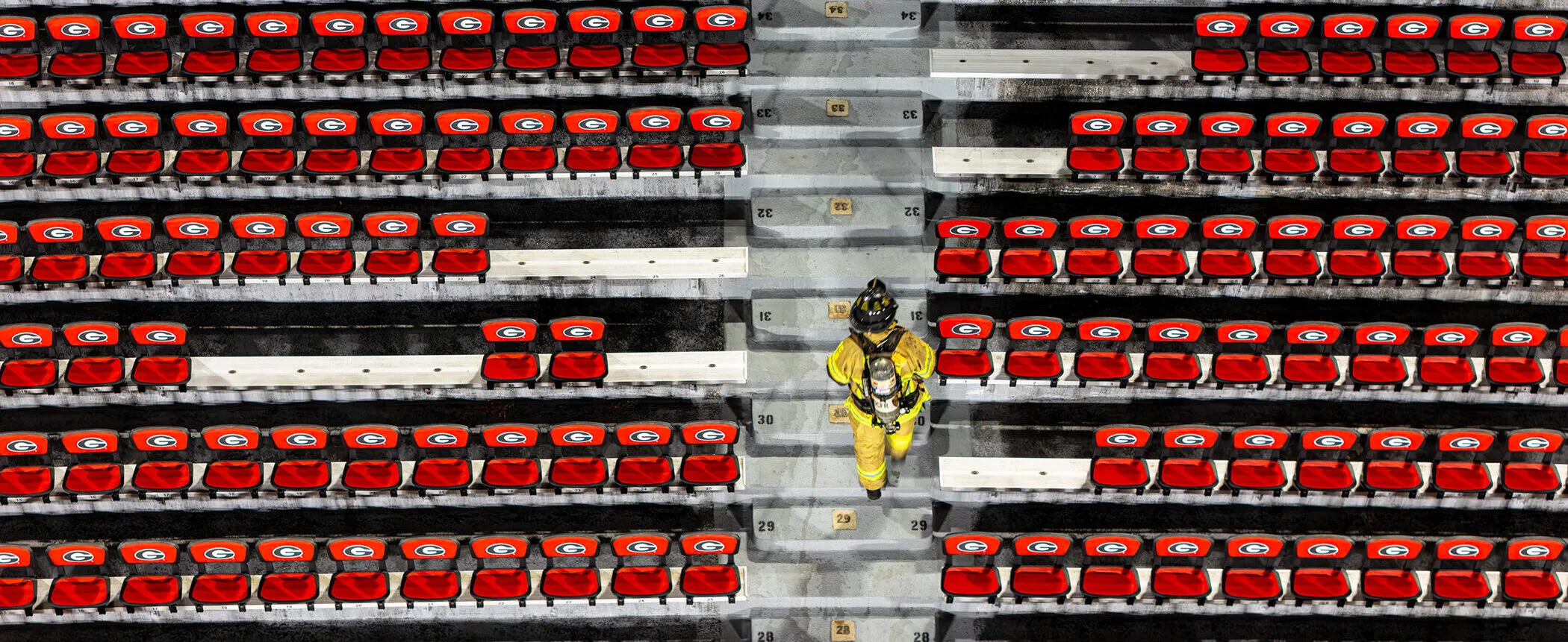 An overhead shot of a firefighter in full turnout gear climbing the steps of Sanford Stadium during the 9/11 memorial stair climb.
