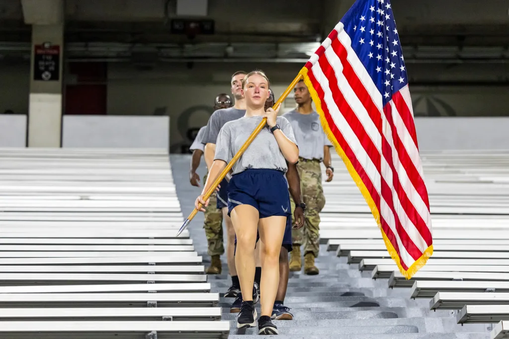 ROTC students descend the stairs of Sanford Stadium during a 9/11 memorial stair climb, with one participant carrying an American flag.
