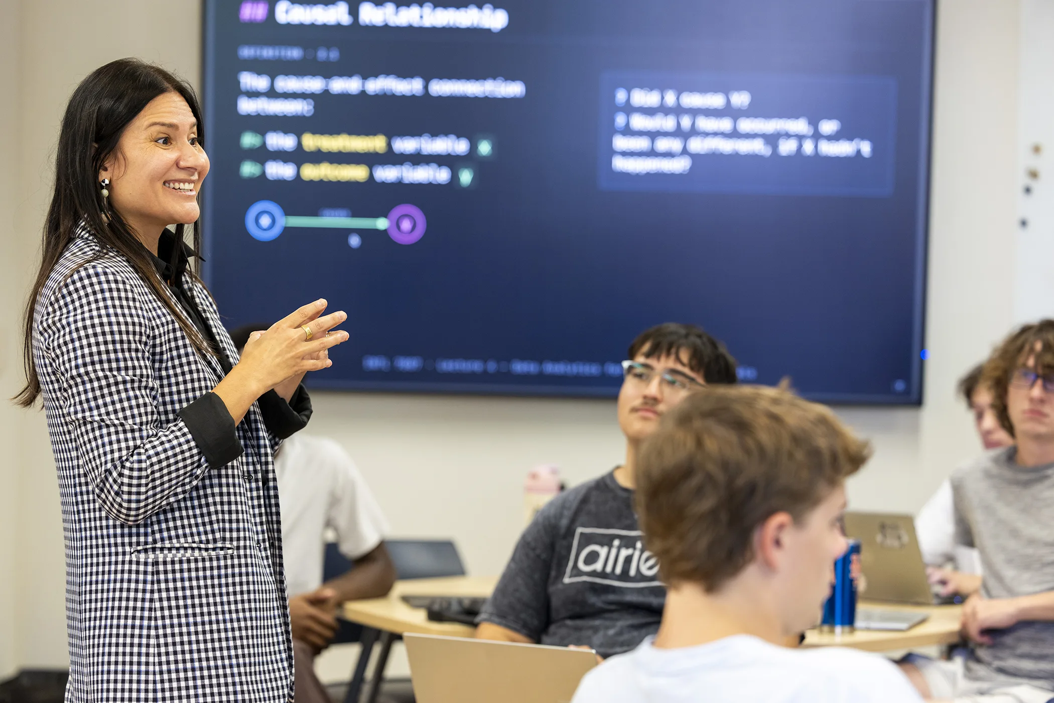 Researcher teaches a graduate class to engaged students. 